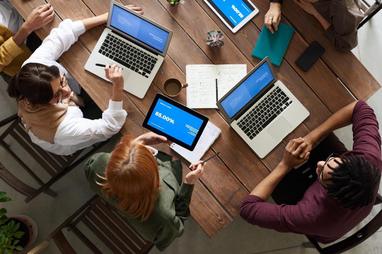 Employees around a table with laptops