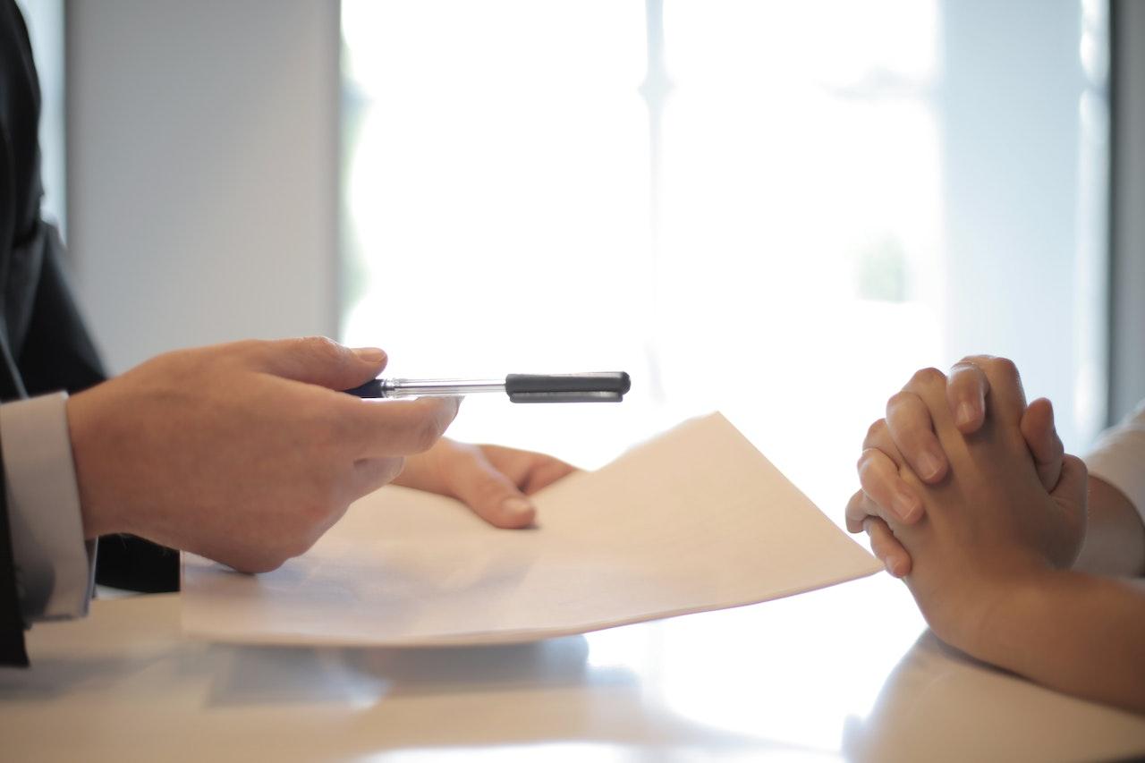 person handing over a contract to sign