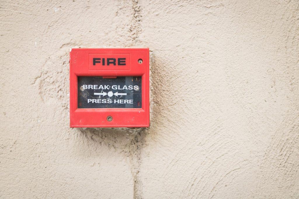 red and black fire alarm on a wall