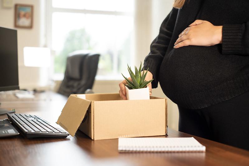 pregnant woman packing up her things in an office