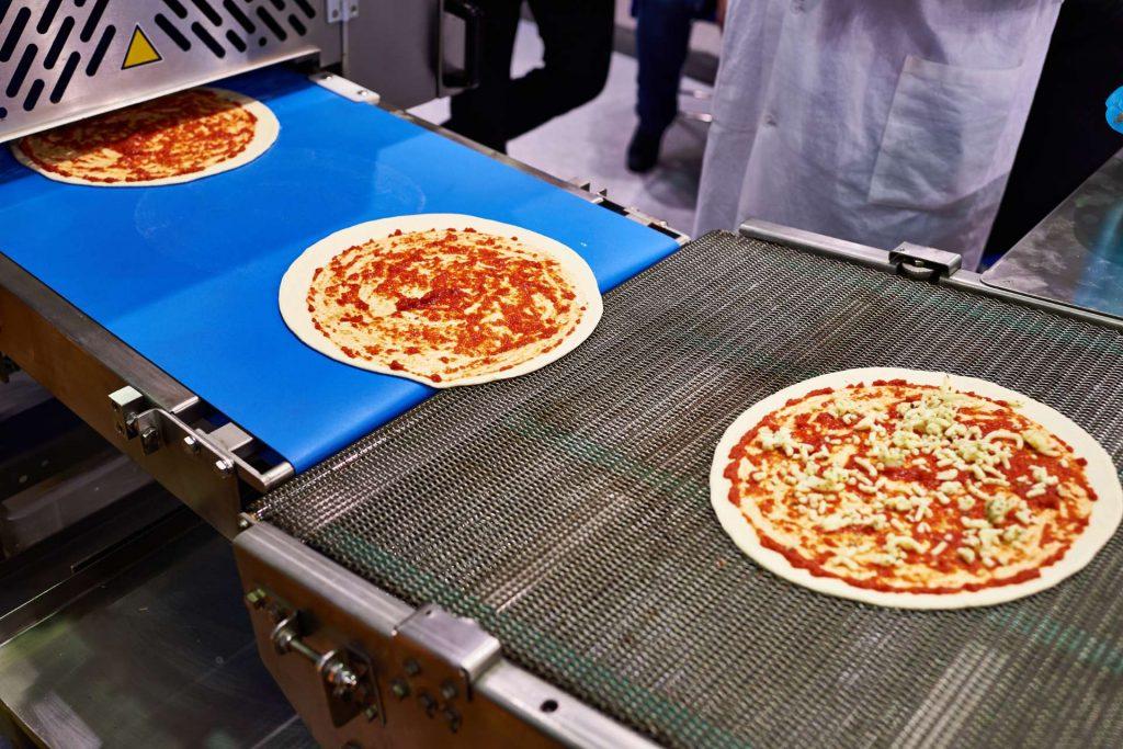 Pizzas on a conveyor belt